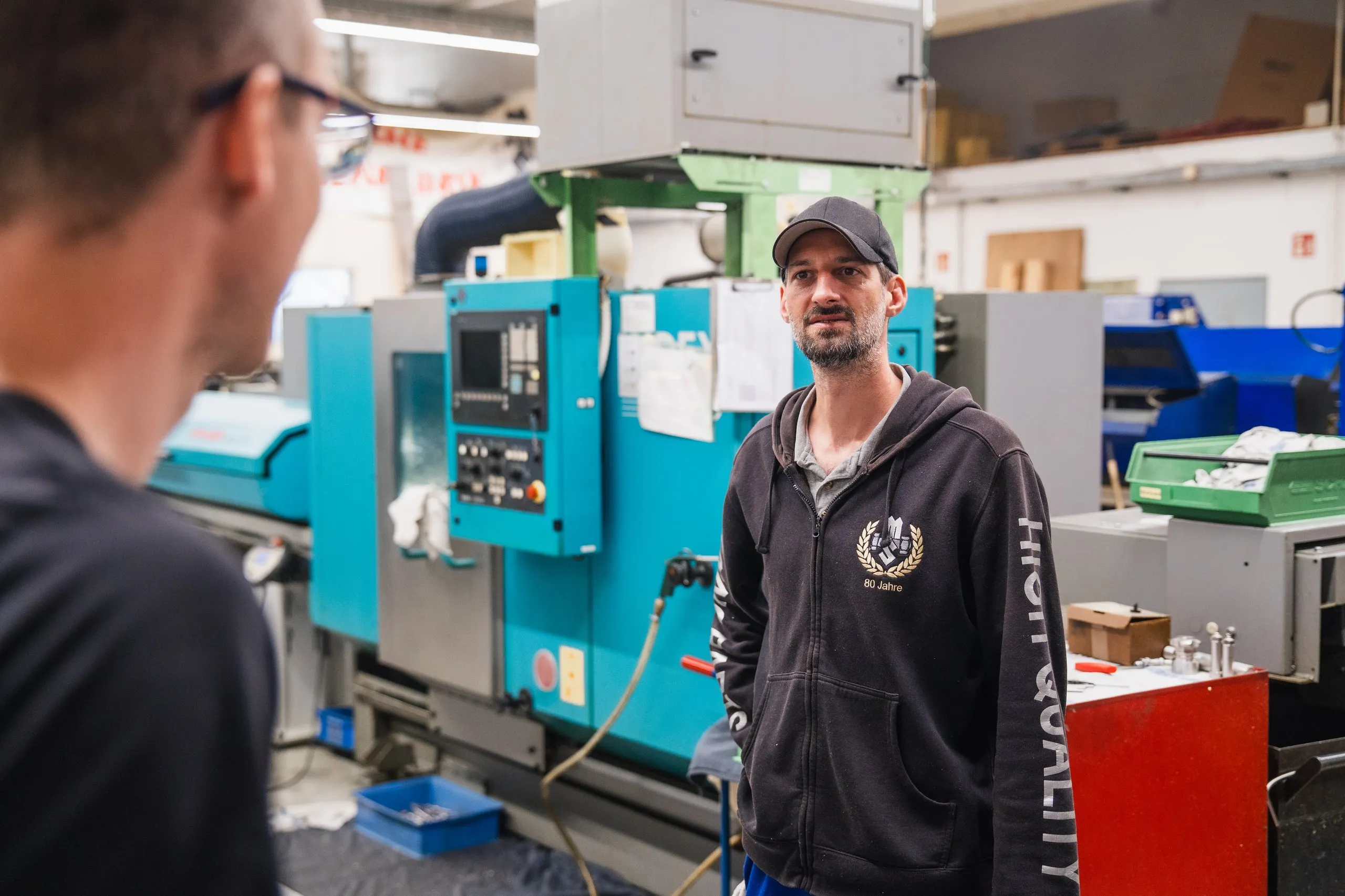 Mitarbeiter im Gespräch in der CNC-Fertigung